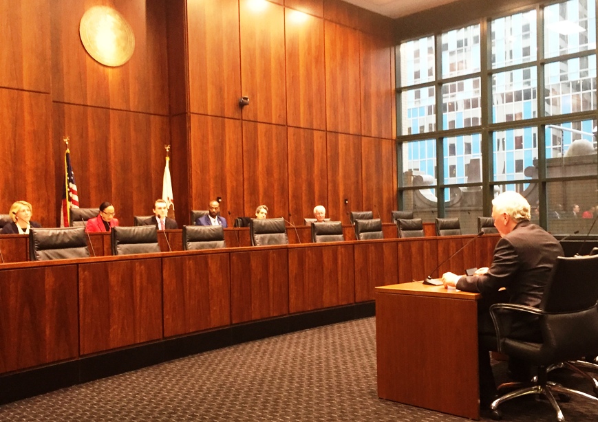 Rebel Cole testifying at a witness table before the Illinois Senate committee